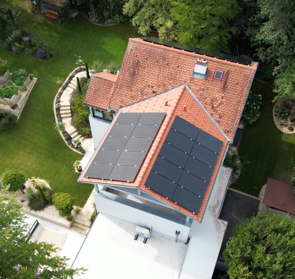 Drohnenaufnahme eines Einfamilienhauses mit Photovoltaikmodulen am Dach