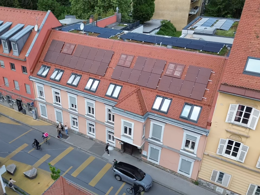 Drohnenfoto von PV-Anlage mit roten Modulen auf Schrägdach